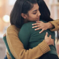 Person comforting another person with a hug