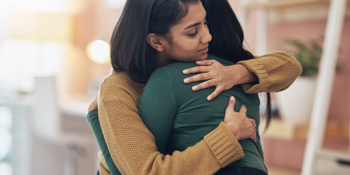 Person comforting another person with a hug