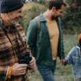 Grandfather, father and son walking in forest