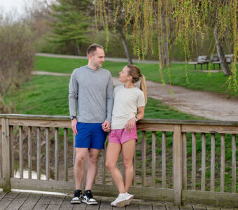 Molly and her partner on a deck with woods in the background