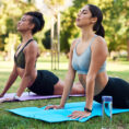 two people doing yoga outdoors