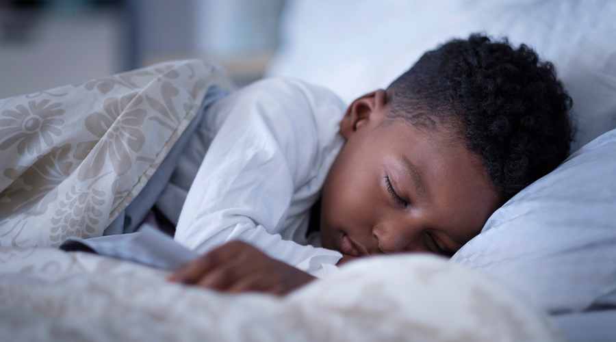 Young boy sleeping in bed