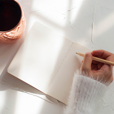 Close up of person journaling. Close of hand getting ready to write.