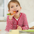 Young female child eating vegetables