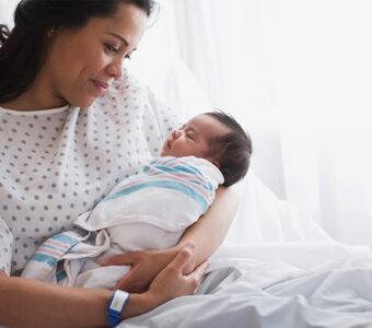 Mother holding newborn baby in hospital after giving birth
