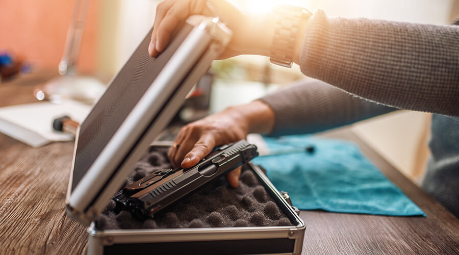 Putting gun in gun safe in home