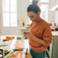 Woman looking at app while cooking