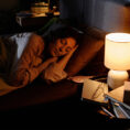 Woman waking up next to lamp