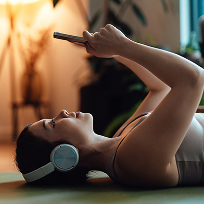 Woman listening to music on yoga mat