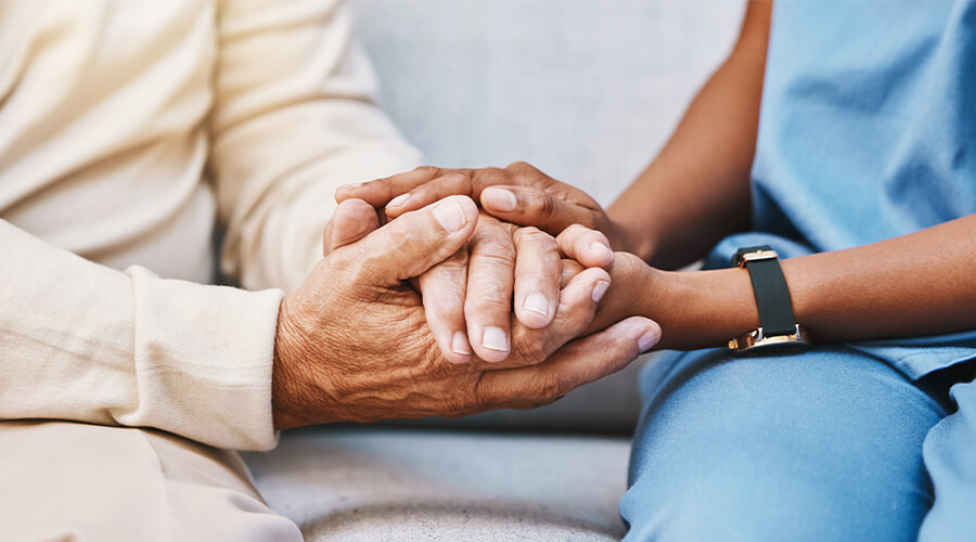 Doctor holding hand of patient providing comfort 