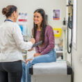 Woman talking to her doctor. Stock photo. Posed by model.