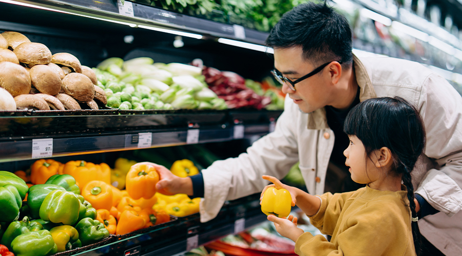 Father and young daughter shopping for produce
