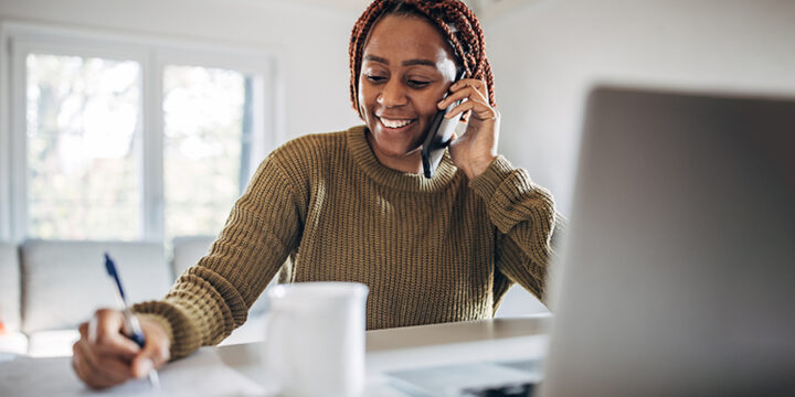 Woman on the phone and taking notes