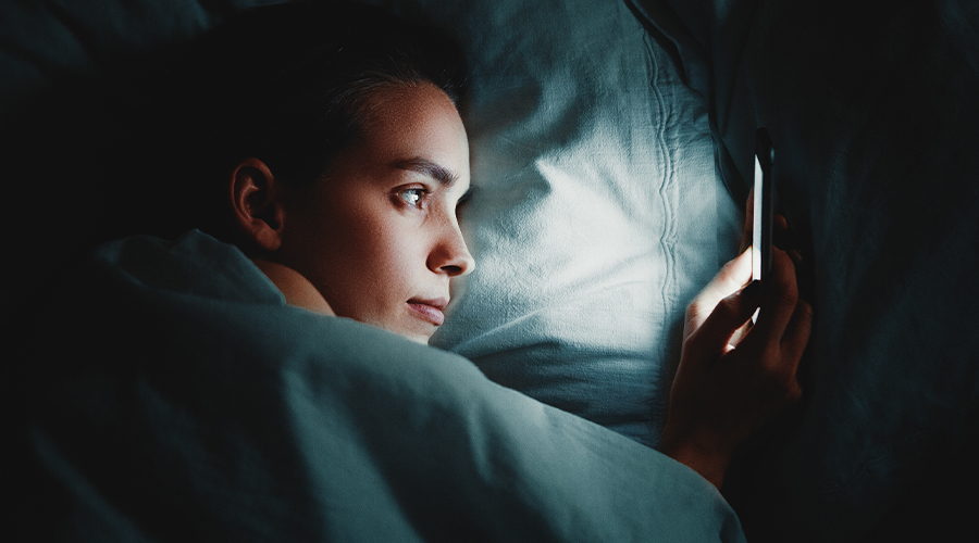 Woman looking at her phone in bed