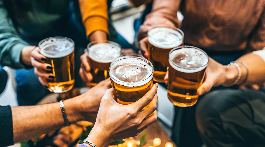 Group of people holding beers together to toast