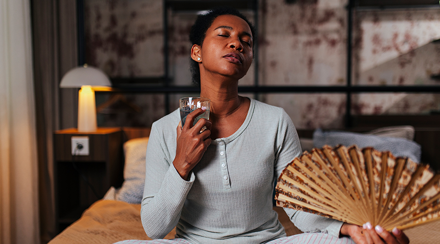 Woman cooling off with fan and water