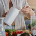 Woman scooping supplement powder from container