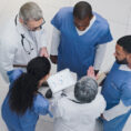 doctors looking at tablet with test results on it